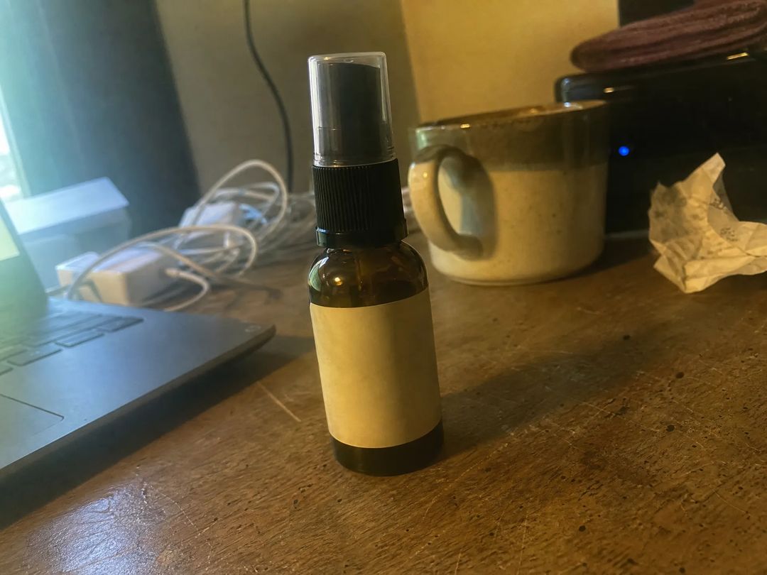 Starting material for AI product photography: an unedited phone photo of a bottle on a cluttered wooden desk