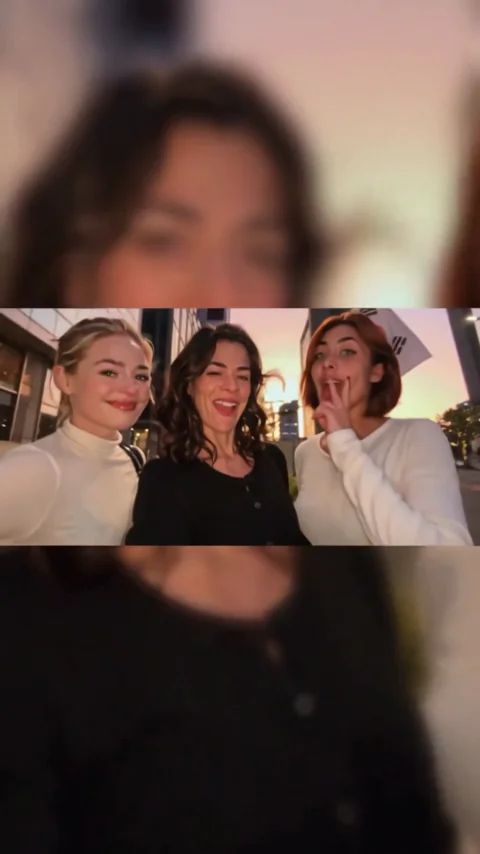 Three women appearing together in a night-street selfie